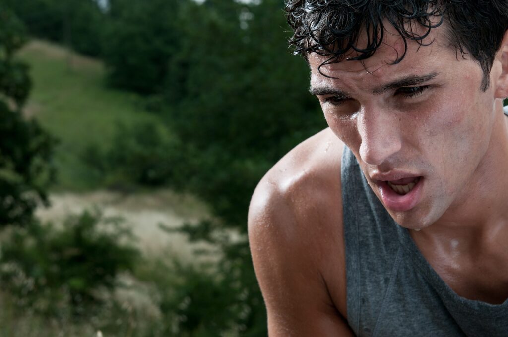 Young athletic man taking a break during a challenging jogging o
