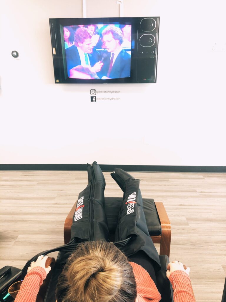 Person watching TV while lounging with compression boots